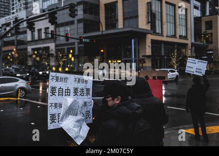 Bellevue, Stati Uniti. 04th Dec, 2022. Un protester tiene un cartello durante la dimostrazione. I manifestanti hanno tenuto un rally sotto la forte pioggia in solidarietà con il popolo Urumqi a Bellevue, Seattle. In Cina, il "Libro bianco" era noto come la "Rivoluzione del A4". Nel Bellevue Downtown Park, una ventina di manifestanti si sono riuniti per manifestare contro la politica cinese di 'zero-covid' e per pregare per le vittime del tragico incendio di Urumqi. Credit: SOPA Images Limited/Alamy Live News Foto Stock