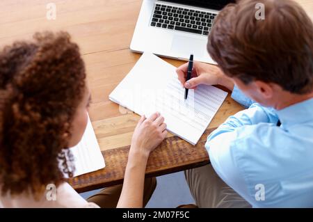 Queste cifre sono grandi. Vista dall'alto di due soci aziendali che lavorano insieme a un documento finanziario. Foto Stock