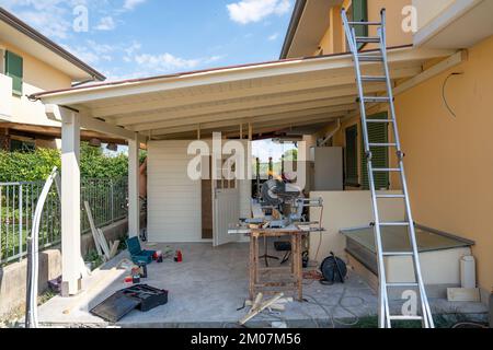 Trasferirsi in una nuova casa. Patio esterno struttura pergolato ombra, tetto patio e gazebo in legno in costruzione, giardino lounge. Foto Stock