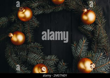 Natale o Capodanno giocattolo decorazioni palle d'oro e ramo di pelliccia albero rustico su sfondo di legno, vista dall'alto, copia spazio Foto Stock