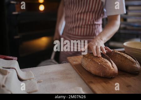 Primo piano del panettiere con pane fresco. Foto Stock