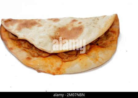 Tradizionale cucina Araba Siriana di uno spuntino al forno chiamato Manakish un pane mediorientale simile alla pizza farcita con pezzi di pollo come un panino Foto Stock