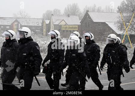 05 dicembre 2022, Renania settentrionale-Vestfalia, Lützerath: Poliziotti in piedi vicino al villaggio di Lützerath. La polizia di Aquisgrana ha avuto un quadro della situazione nel villaggio di Lützerath. L'operazione è stata effettuata solo a scopo di ricognizione e non rappresenta espressamente l'inizio dell'evacuazione. Lützerath sarà evacuato più tardi a causa della lignite a cielo aperto. Foto: Federico Gambarini/dpa Foto Stock