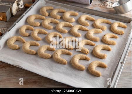 Vanillekipferl appena sfornato, biscotti di natale tradizionali tedeschi su una teglia da forno Foto Stock