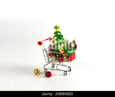 Carrello con palle di natale e albero con ghirlande. Sfondo semplice. Foto Stock