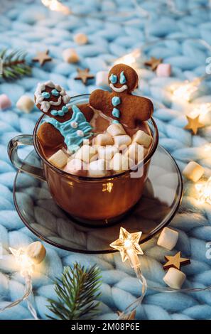 Concetto di coppia spa vacanza di Natale. Coppia donna e un uomo fatto di un pan di zenzero che immergersi in una tazza di cioccolata calda con marshmallows, accogliente. Foto Stock