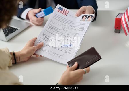 Primo piano della donna che riceve il visto negli Stati Uniti presso l'ufficio immigrazione e che detiene moduli approvati Foto Stock