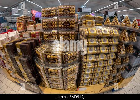 Bra, Cuneo, Italia - 30 novembre 2022: Pallet d'oro che espongono scatole regalo Ferrero Collection con cioccolatini Rocher in vendita al supermercato italiano Foto Stock