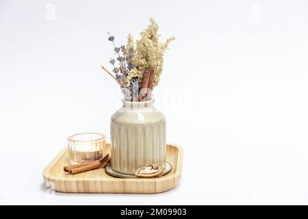 Vaso con fiori secchi e una candela su uno sfondo bianco isolato. Foto Stock