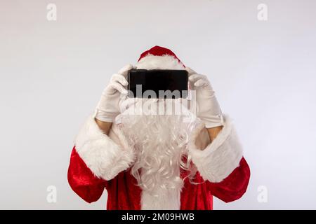 modello di babbo natale parlare e utilizzare il telefono cellulare su uno sfondo bianco Foto Stock