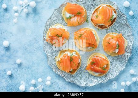 Blini con salmone affumicato e panna acida, guarniti con aneto Foto Stock