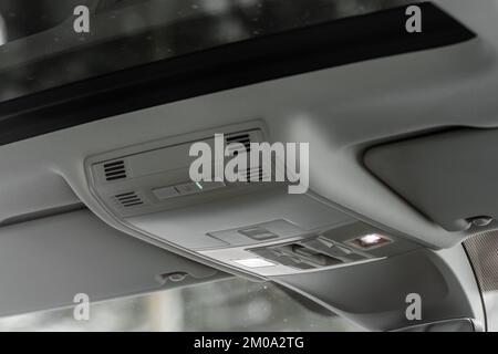 Immagine ravvicinata del pulsante SOS e della plafoniera di un'auto. Foto Stock