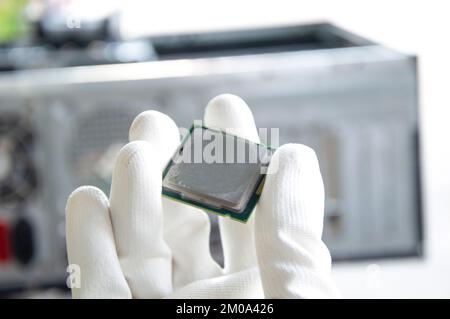 Immagine di un tecnico che tiene in mano una CPU. Foto Stock