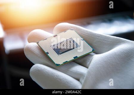Immagine di un tecnico che tiene in mano una CPU. Foto Stock