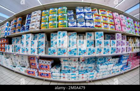 Cuneo, Italia - 30 novembre 2022: Scaffali con esposizione di confezioni di carta igienica di diverse marche in vendita nel supermercato italiano, vista fish eye Foto Stock