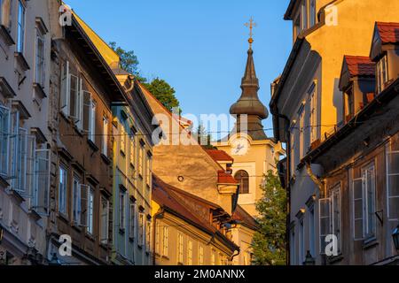 Tramonto nella città vecchia di Lubiana in Slovenia. Case tradizionali lungo la via Gornji Trg e la torre di St Chiesa di Florian (sloveno: Cerkev sve Foto Stock