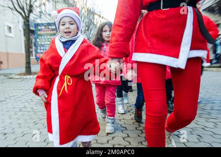 UZHHOROD, UCRAINA - 4 DICEMBRE 2022 - i bambini vestiti di costumi di Capodanno prendono parte alla parata di beneficenza degli aiutanti di San Nicola tenuta sotto la s Foto Stock