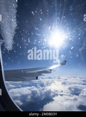 Un primo piano di Airplane Wing contro il cielo blu e le nuvole bianche Foto Stock