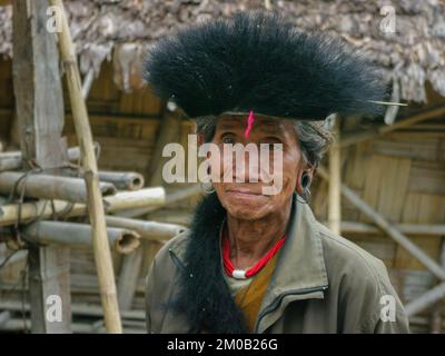 Raga, Arunachal Pradesh, India - 11 14 2010 : Ritratto dello sciamano della tribù di Nyishi che indossa la tradizionale bretella con pelliccia nera, collana rossa e orecchini Foto Stock