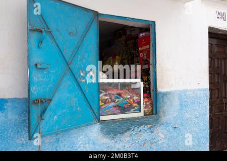 Tetouan, Marocco - 19 aprile 2019: Chiosco con un piccolo banco caramelle installato in una finestra con una porta di metallo blu. Foto Stock