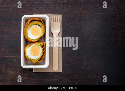 Spuntino fritto olandese della provincia di Groningen chiamato Eierbal sul tavolo, uova sode con ragù e pangrattato Foto Stock