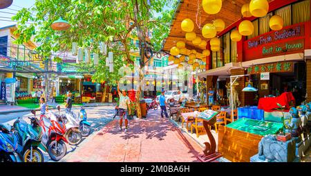 BANGKOK, THAILANDIA - 23 APRILE 2019: Il viale Rambuttri con ristoranti turistici, piccoli negozi e banyan albero con le radici aeree pendenti, il 23 aprile i Foto Stock