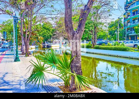 Passeggiata all'ombra lungo il canale ROP Krung nel quartiere Phra Nakhon di Bangkok, Thailandia Foto Stock