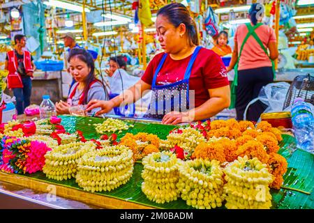 BANGKOK, THAILANDIA - 23 APRILE 2019: Fare ghirlande di fiori da gelsomino, merigolds con rose sul mercato dei fiori Pak Khlong Talat, il 23 aprile a Bangko Foto Stock