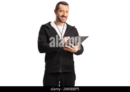 Allenatore sportivo con un fischio che tiene un clipboard e sorridente isolato su sfondo bianco Foto Stock