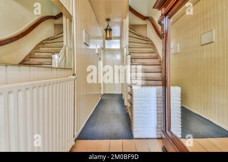 Corridoio con scalinata che conduce al secondo piano e lampada luminosa Foto Stock