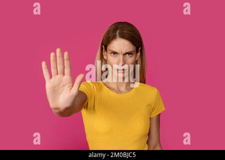 Grave triste sicuro adulto donna caucasica bionda in t-shirt gialla mostra mano di palma Foto Stock