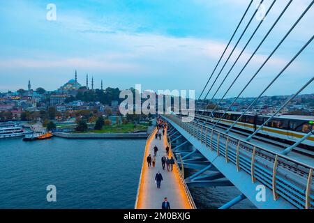 Golden Horn o Halic Metro Bridge. Persone sul ponte e Moschea Suleymaniye sullo sfondo. Istanbul Turkiye - 10.15.2021 Foto Stock