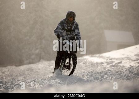 Sofia, Bulgaria - 22 gennaio 2022: Il ciclista percorre una discesa in bicicletta durante una gara estrema di mountain bike sulla neve sul monte Vitosha. Foto Stock
