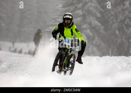 Sofia, Bulgaria - 22 gennaio 2022: Il ciclista percorre una discesa in bicicletta durante una gara estrema di mountain bike sulla neve sul monte Vitosha. Foto Stock