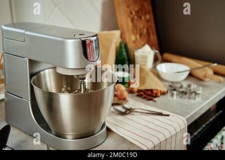 Preparazione dell'impasto in un mixer elettrico a casa. Mixer professionale per impastare e preparare ingredienti alimentari all'interno della cucina. Elettrodomestici moderni in cucina Foto Stock