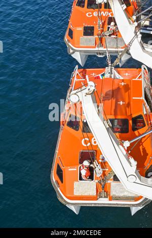 Argostili, Grecia - 2022 giugno: Membro dell'equipaggio che lavora su una scialuppa di salvataggio per abbassare la nave da crociera per portare i passeggeri a terra per visitare la città Foto Stock