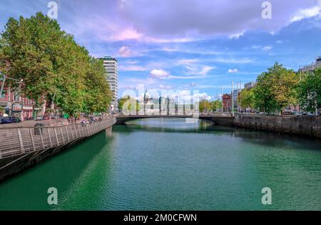 Le banchine di Dublino che corrono lungo le rive del fiume Liffey con il ponte Rosie Hackett sullo sfondo. Foto scattata dal ponte o'Connell. Foto Stock