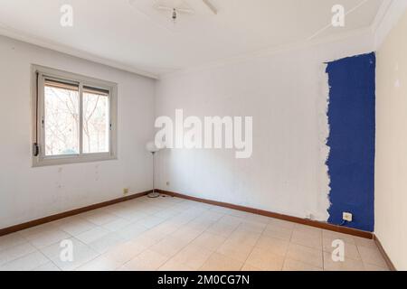 Camera vuota e spaziosa con finestra e pareti sporche in un vecchio appartamento prima di essere ristrutturata. Foto Stock