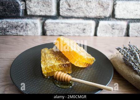 Concetto di prodotti a nido d'ape freschi, a nido d'ape e d'ape, ingredienti naturali biologici sul tavolo. Foto Stock