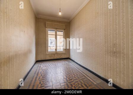 Stanza vuota in una vecchia casa che sembra una capsula del tempo con pavimenti idraulici in piastrelle e pareti tappezzate e sporche finestre di legno Foto Stock