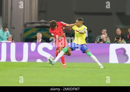 DOHA, QATAR - 5 DICEMBRE: Il giocatore del Brasile Raphinha combatte per la palla con il giocatore della Corea del Sud Kim Jin-su durante la Coppa del mondo FIFA Qatar 2022 Round of 16 match tra Brasile e Corea del Sud allo Stadio 974 il 5 dicembre 2022 a Doha, Qatar. (Foto di Florencia Tan Jun/PxImages) Foto Stock