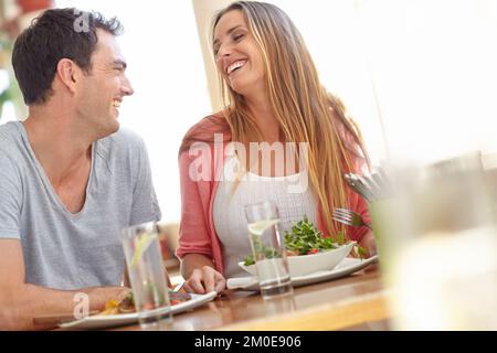 Gustando un delizioso pranzo insieme. Una giovane e felice coppia gustando un gustoso pranzo in un ristorante. Foto Stock