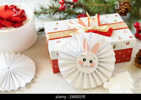 Auguri buon Natale e buone Feste Capodanno. Albero di Natale, scatole di regali e simbolo di anno lunare calendario cinese, anno del coniglio. Foto Stock