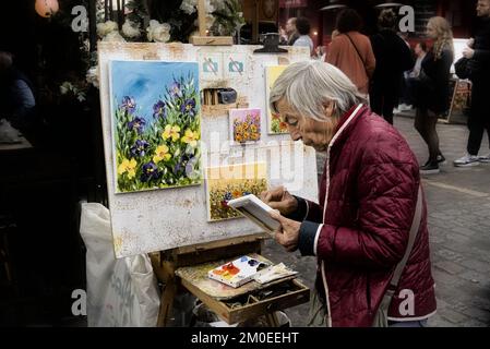 Una donna artista che lavora alla sua pittura a Parigi. Foto Stock