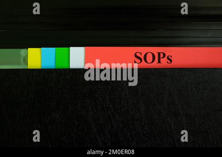 Record del file SOP di prelievo a mano nella cartella raccoglitore nero. Concetto di procedura operativa standard. Foto Stock