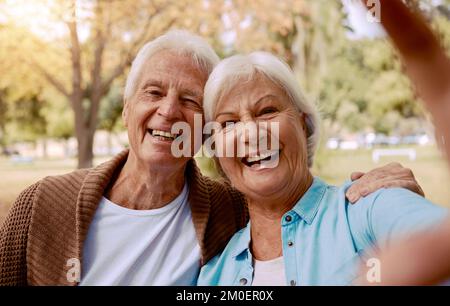 Amore, sorriso e selfie con la vecchia coppia nel parco per unire, rilassarsi e affetto insieme. Pensionamento, natura e felice con il ritratto di uomo e donna Foto Stock