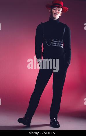 Moda, vitiligine e pelle con un modello uomo nero in studio su sfondo rosso per uno stile alla moda o unico. Ritratto, creativo e audace con un Foto Stock