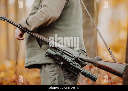 Cacciatore o ranger con pistola o fucile nella foresta caccia di alcuni veleno, periodo di caccia, stagione autunnale, caccia e concetto di persone Foto Stock