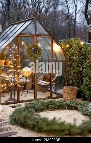 Bellissimo cortile con la glasshouse vintage e la corona di Natale in inverno Foto Stock