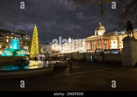 LONDRA, UK - 6th DEC 2022: Trafalgar Square a Londra a Natale. Mostra un albero di Natale, bancarelle di mercato e una fontana. Le persone possono essere viste. Foto Stock